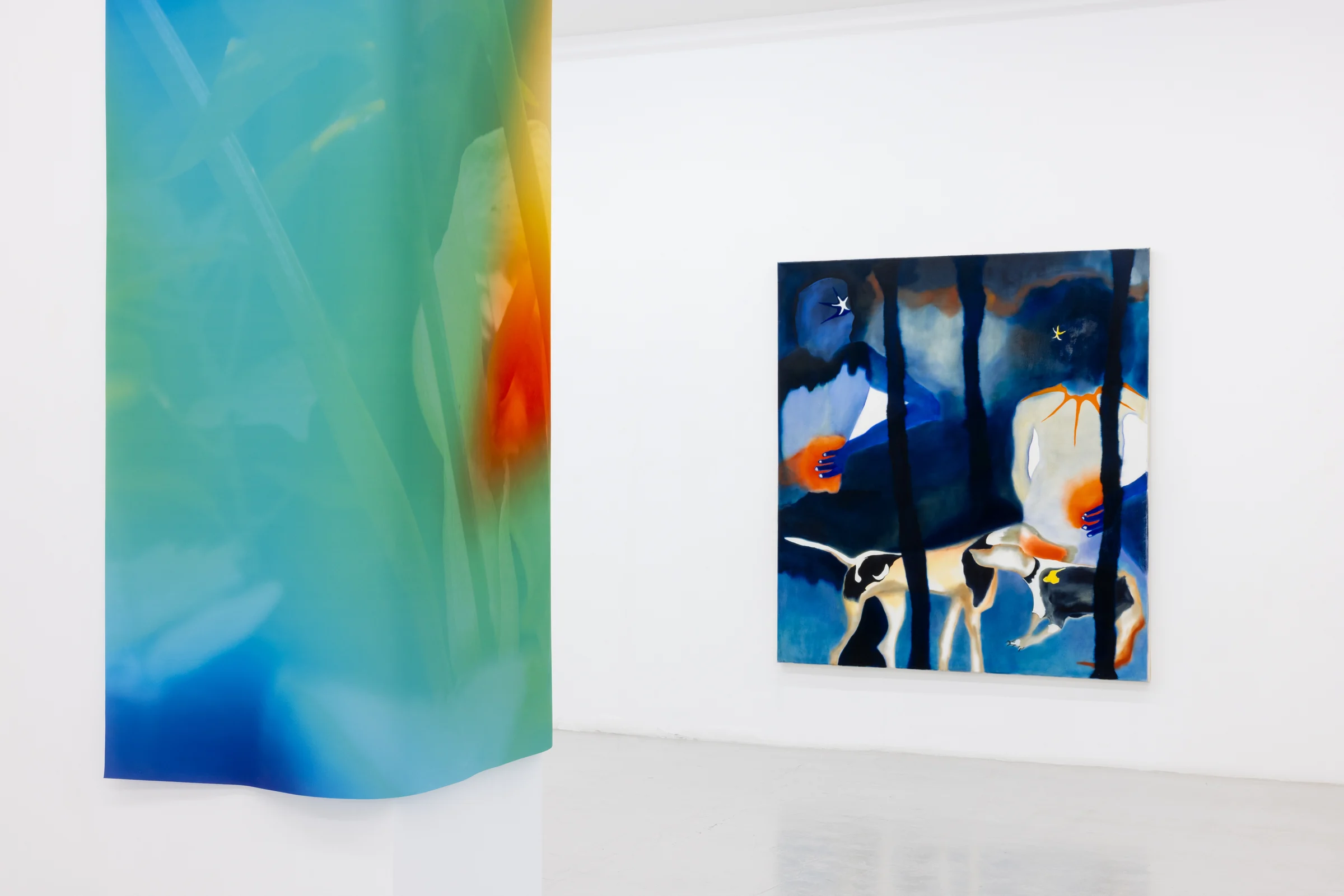 A colourful hanging work and a blue painting installed in Awaiting Climax at Cassina Projects.